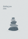 Holding you close. Sympathy card with a small stack of river stones in soft slate blue on cool grey paper